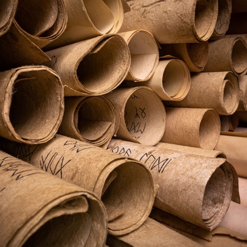 Ancient scrolls stacked on pile. Old and damaged scroll library