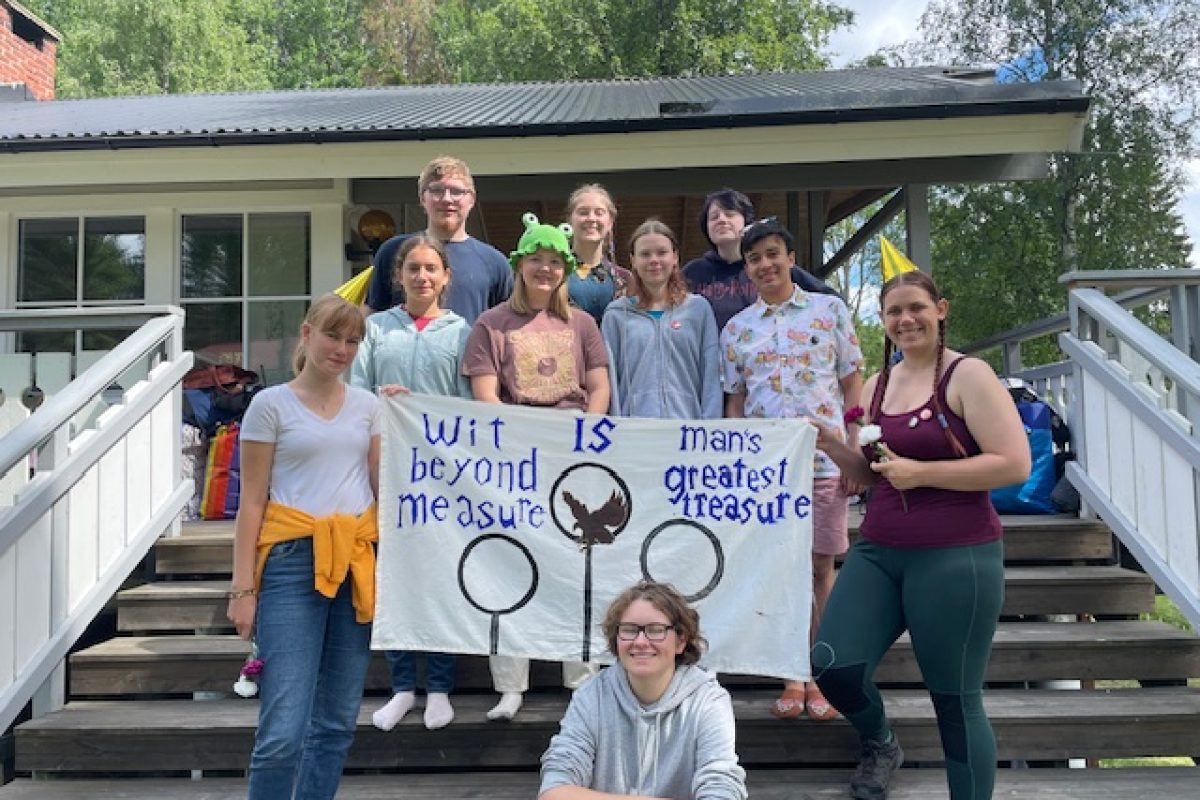 en samling medlemmar lyfter en banner inspirerad av Harry Pottervärlden